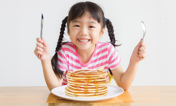 VI-kids-girl-w-pancakes-575×350 | Gilbert Gateway Towne Center